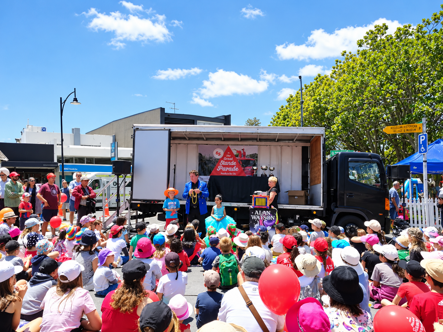 Alan Watson performing an outdoor family magic show for a large audience of children